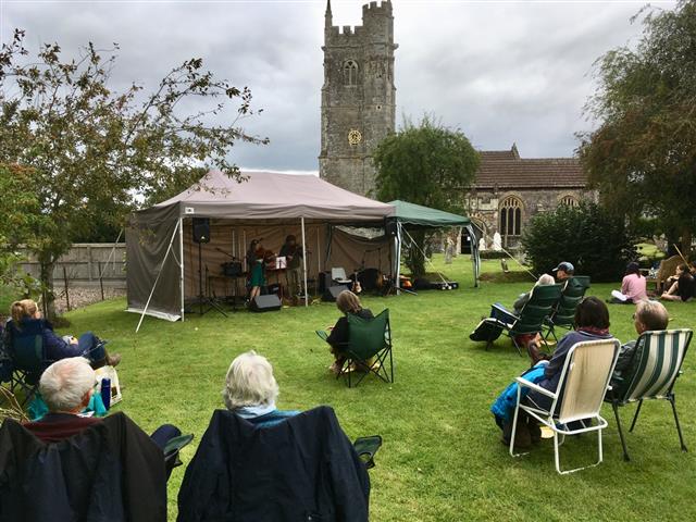 Church, tent and residents sat on the ground